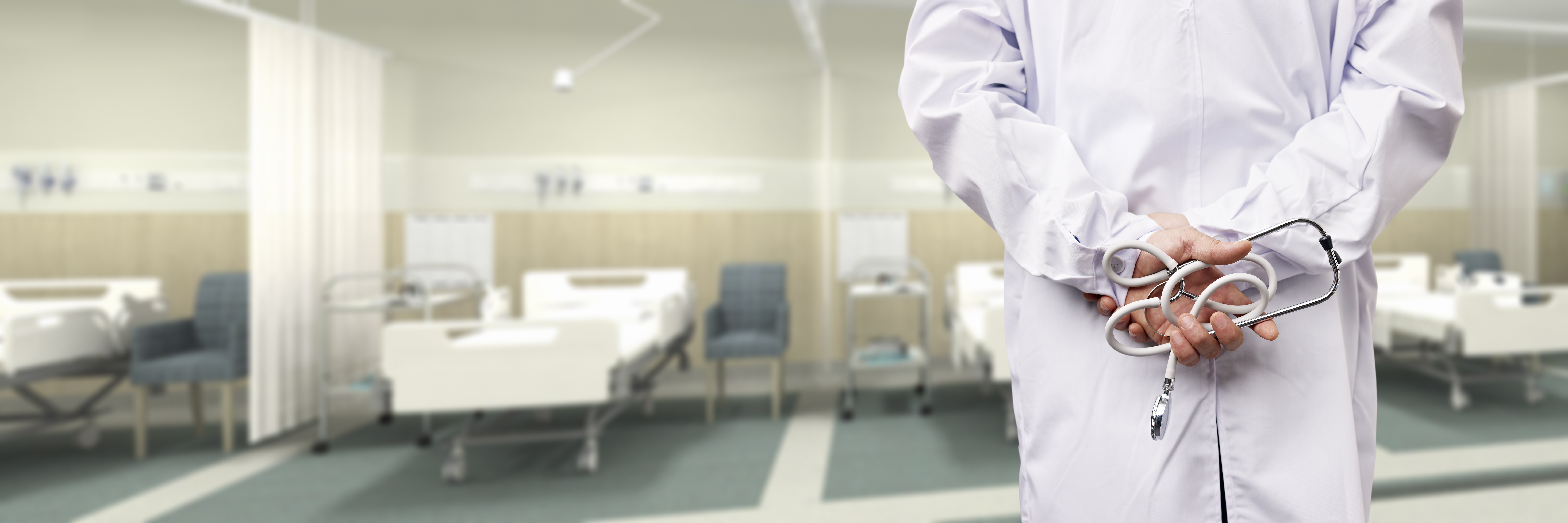 rear view of a male doctor with stethoscope in hospital ward.